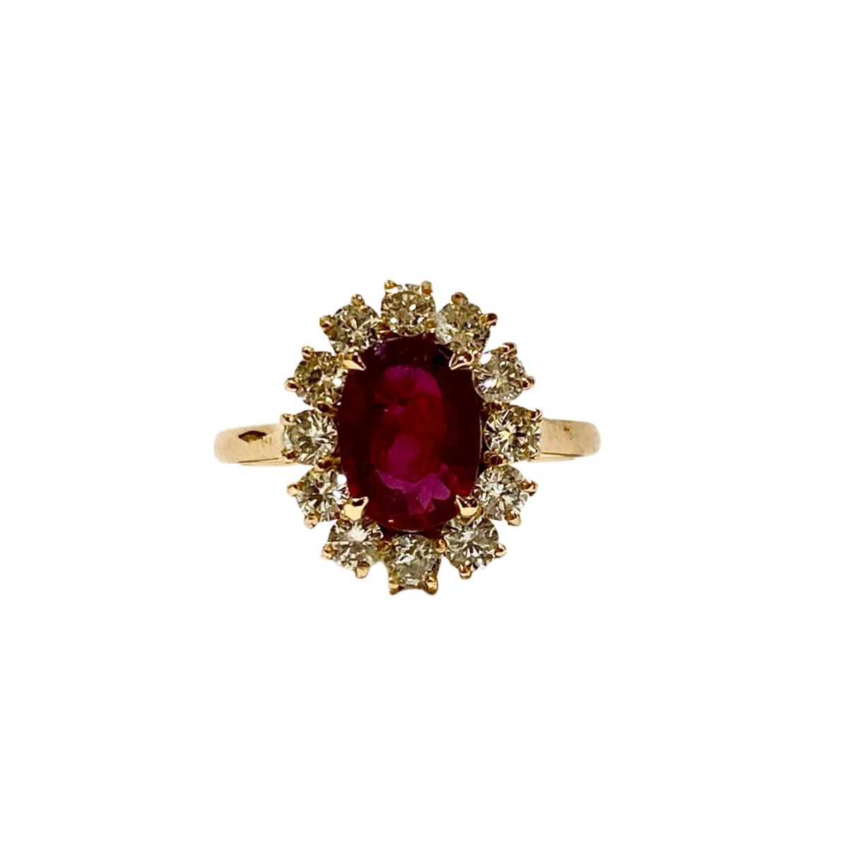 An 18ct yellow gold ring with a central claw-set ruby surrounded by a halo of claw-set brilliant cut diamonds.