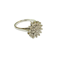 Silver ring with a cluster of diamonds on a light gray background