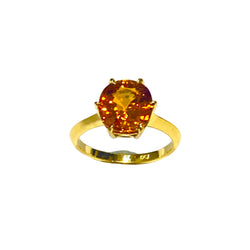 Gold ring with a large amber-colored gemstone on a white background