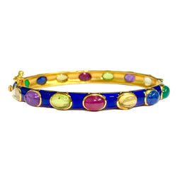 A gold-plated bangle bracelet with a vibrant blue enamel center band and multiple colorful oval inlays, including purple, green, white, and yellow, set against a plain light background.