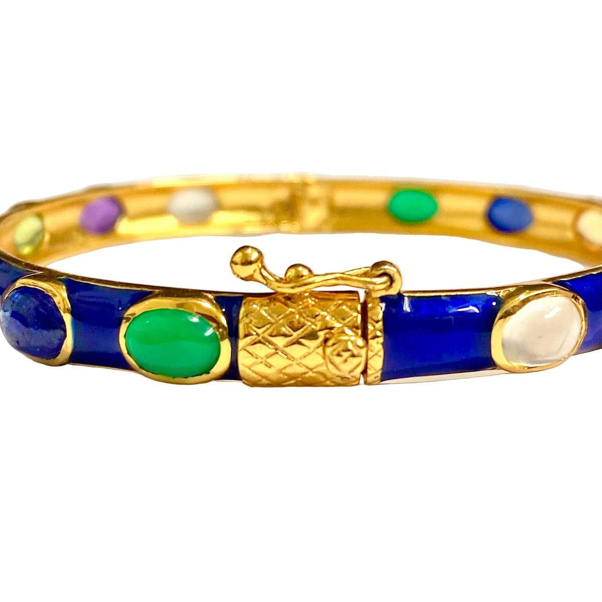A gold-plated bangle bracelet with royal blue enamel sections and oval inlaid stones in green, white, purple, and blue, shown on a plain white background.